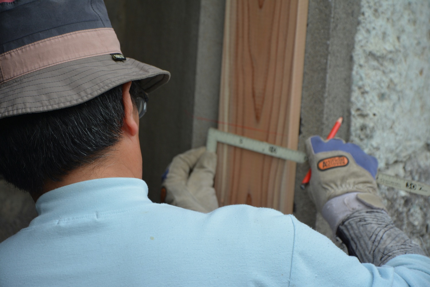 Contractor inspecting and measuring wood framing