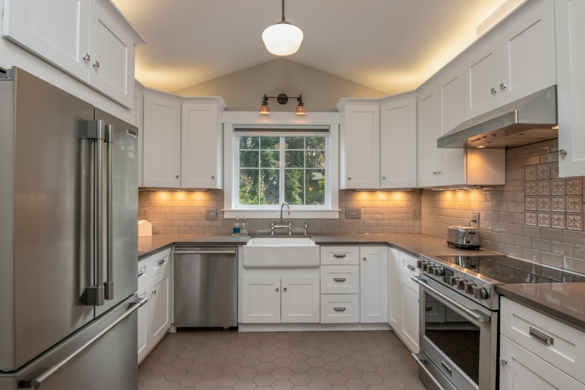 Renovated kitchen with white cabinets and stainless appliances