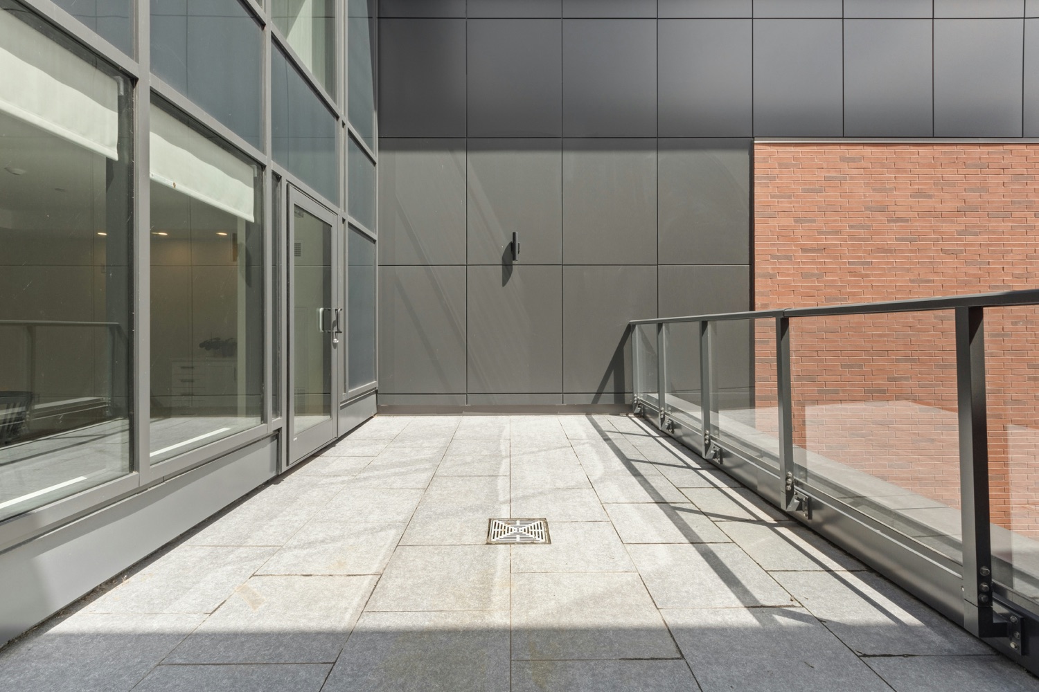 Elevated balcony walkway with glass railing on a multi-story building
